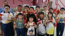 Young chess event participants gathered with organizers in May 2026