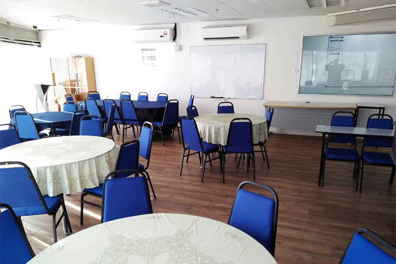 Penang training room arranged with round tables and blue chairs