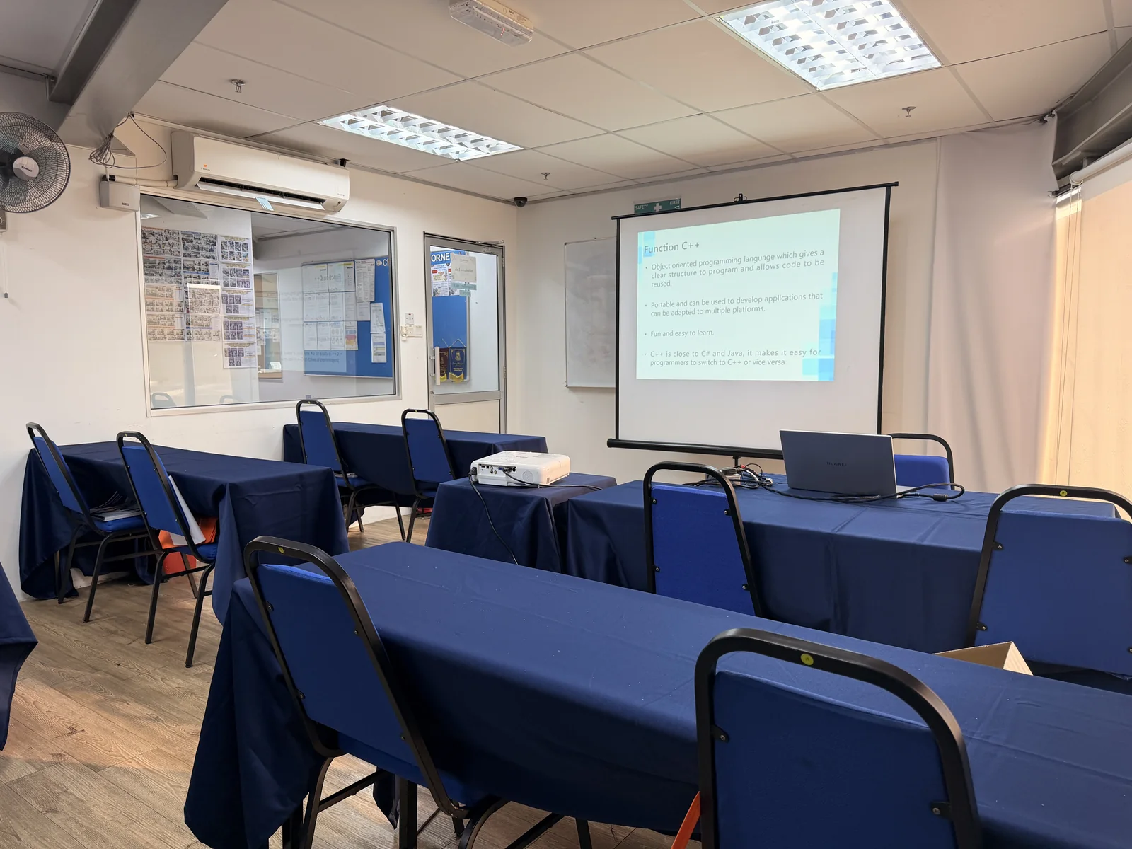 ITPA Penang classroom prepared with blue tables, chairs, projector and presentation screen